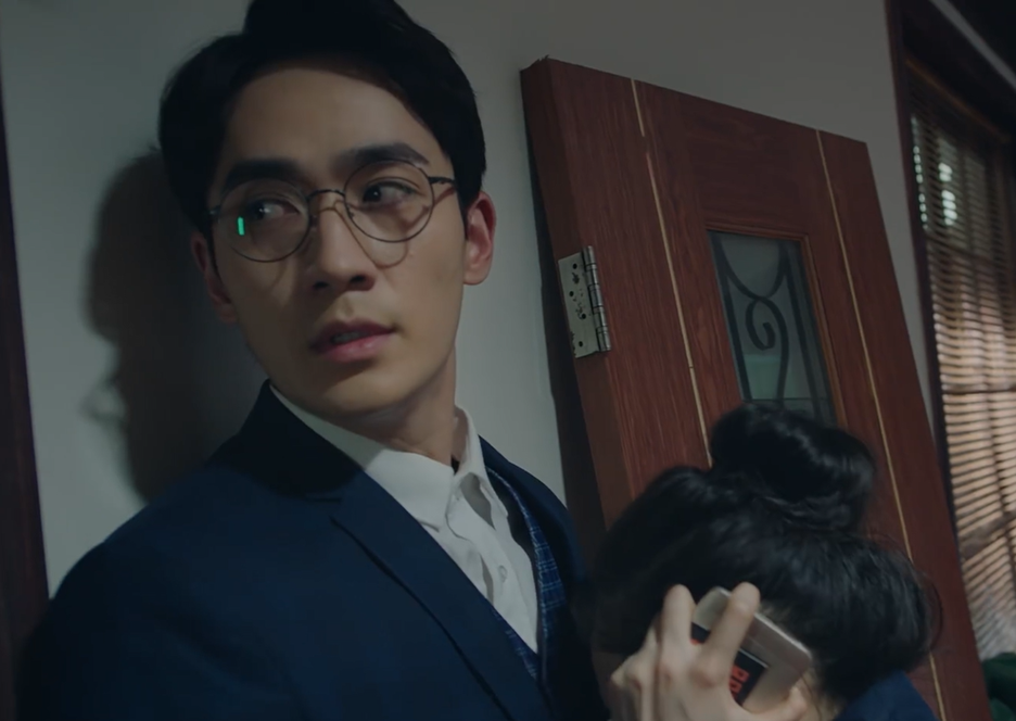 A man and a woman hide in a room.