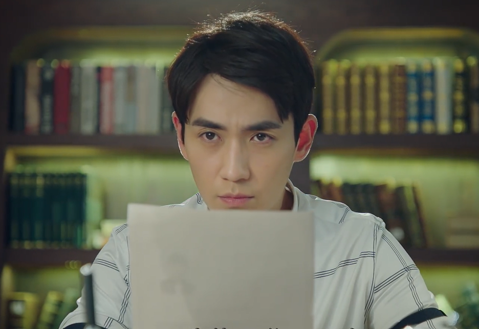 A seated man with a file in front of him.