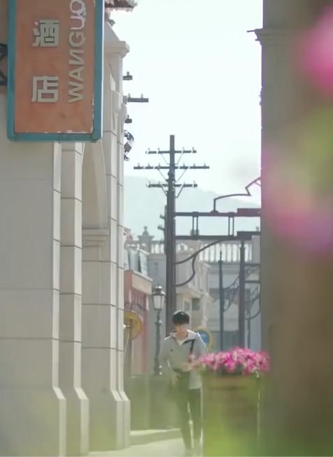 An unfocused picture of Guo Changcheng running down an alleyway.