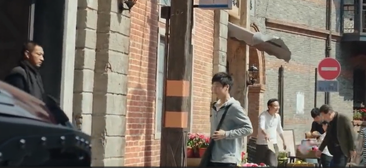 A wide shot of the SID HQ and street with Chu Shuzhi exiting the building to meet Guo Changcheng.